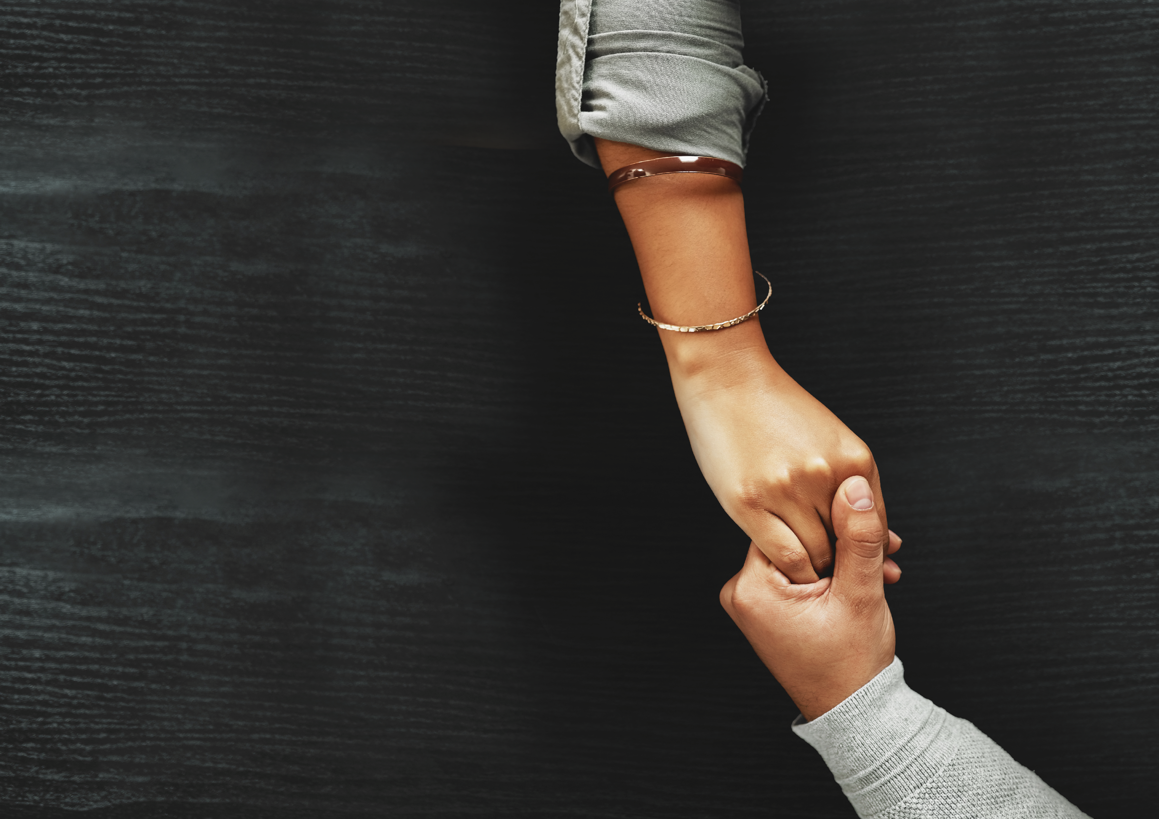 High angle shot of an unrecognizable couple compassionately holding hands at a table