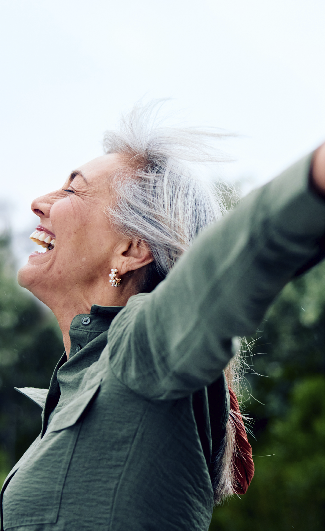 A woman with white hair is smiling and raising her arms in the air. AI generated content