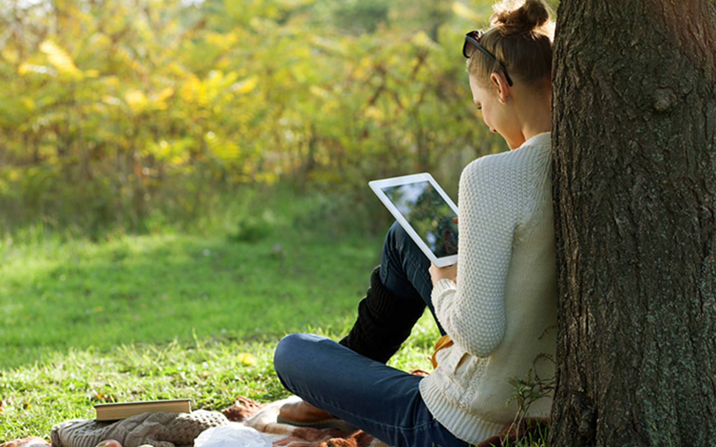 Señora usando un iPad en el parque