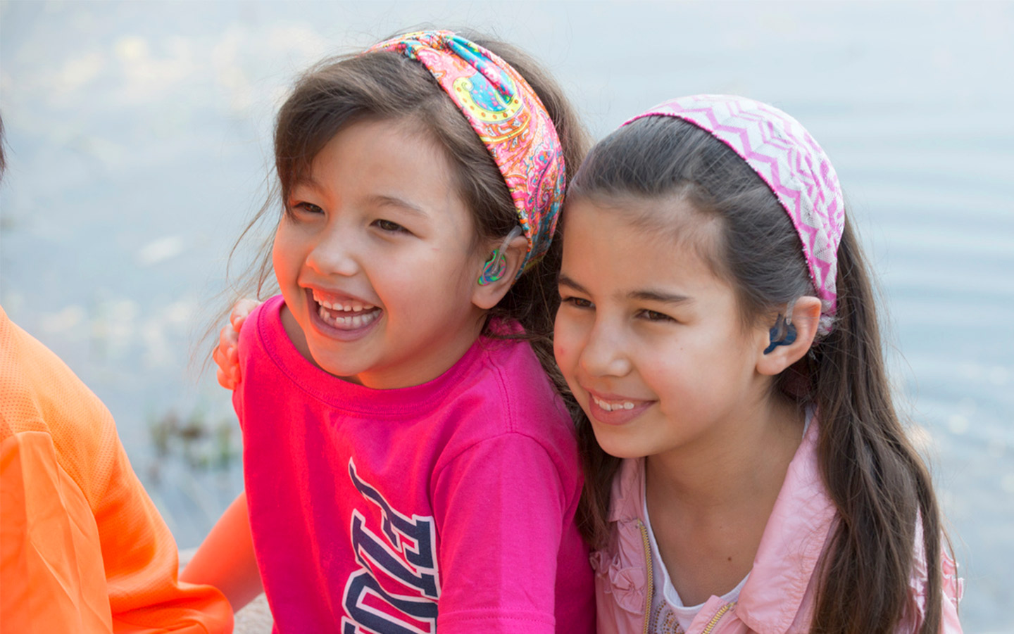 2 meninas em um acampamento usando um implante da Cochlear