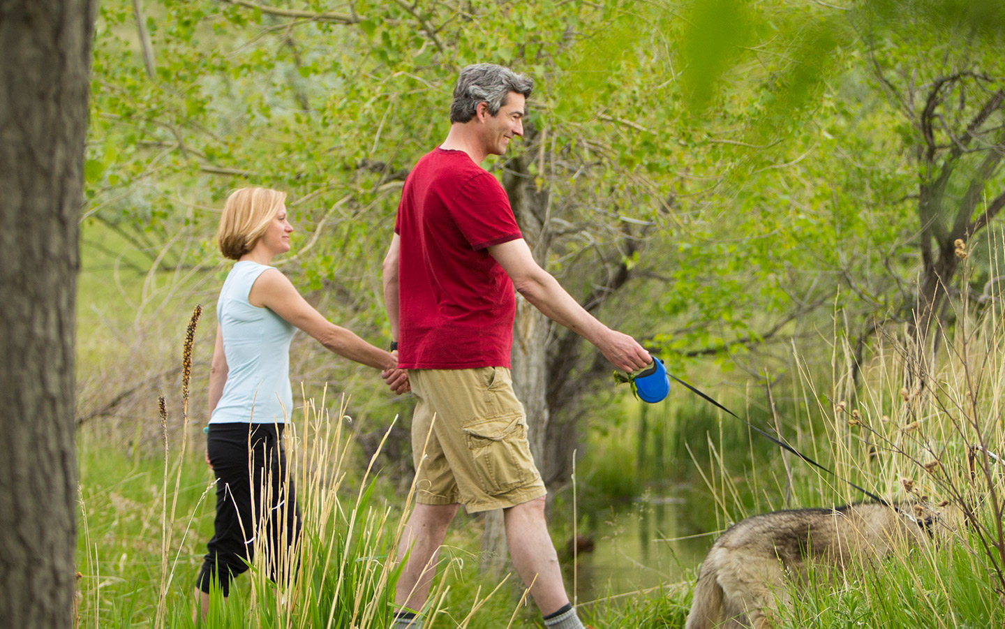 Mattias, usuario de Nucleus de Cochlear, paseando a su perro en el bosque junto a su esposa