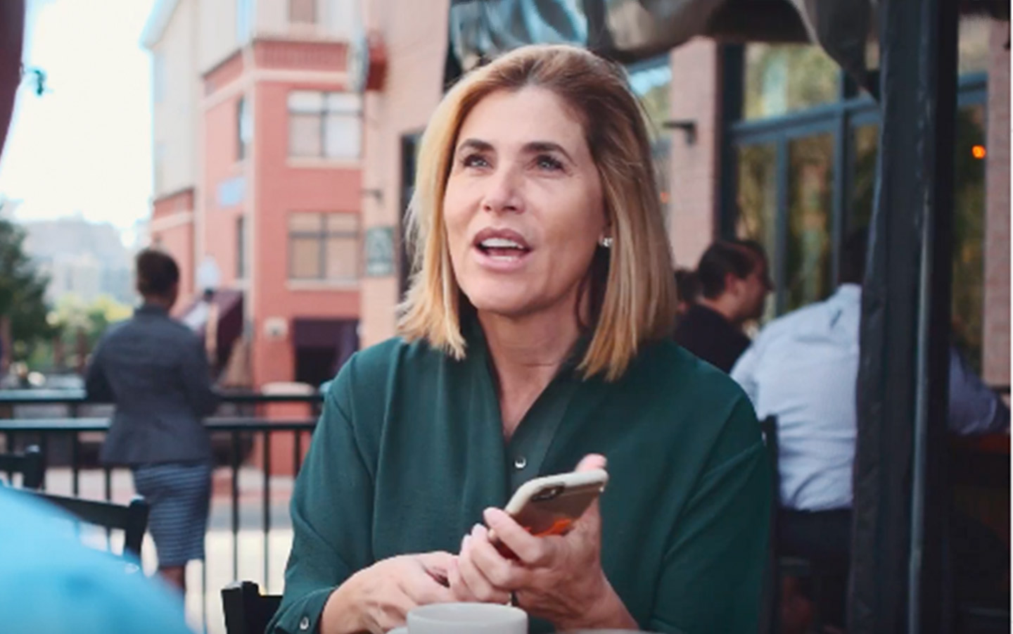 Adriana, usuaria del sistema Baha, en una cafetería con su iPhone