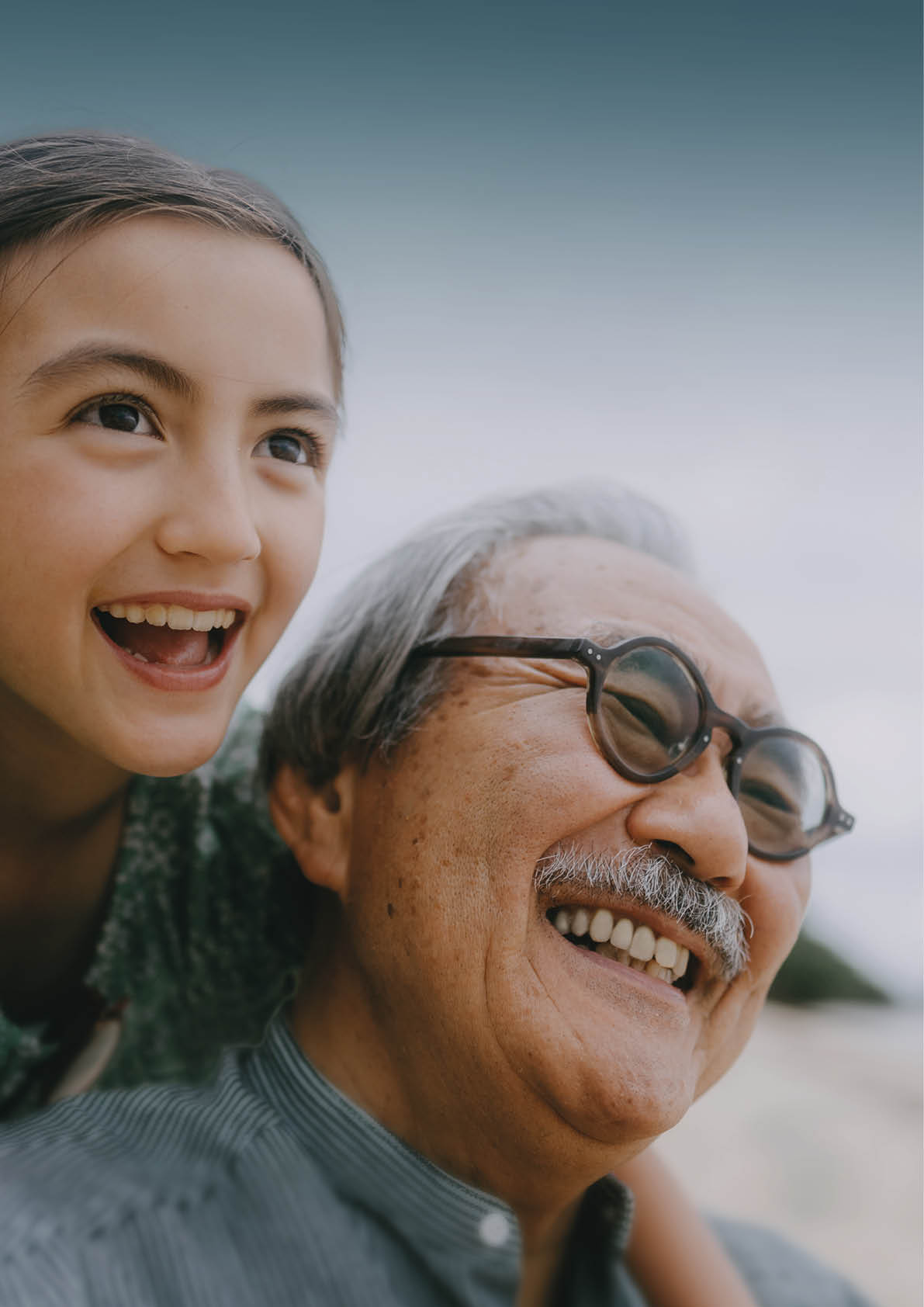 Close up of grandfather and granddaughter having a good time on beach at dusk, Japan